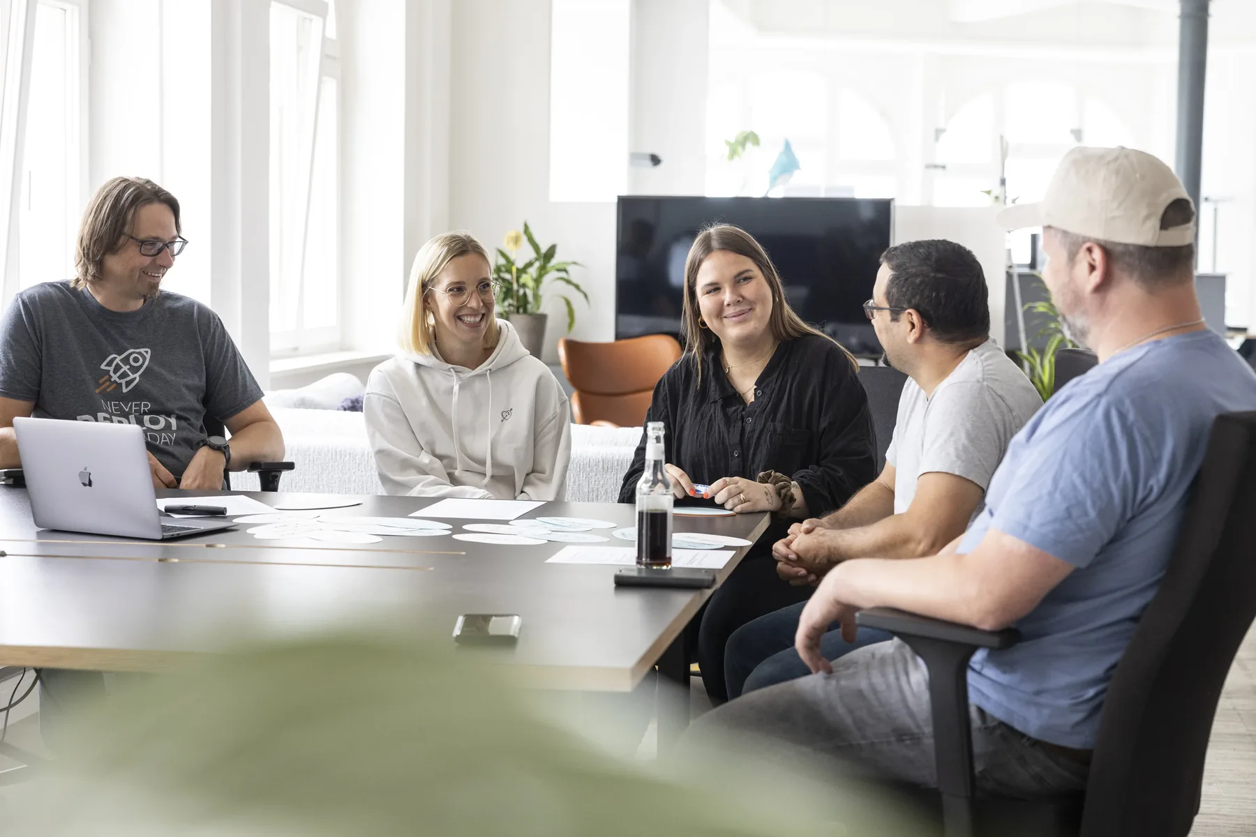 The team around the conference table with laptops and notes in the Hamburg office