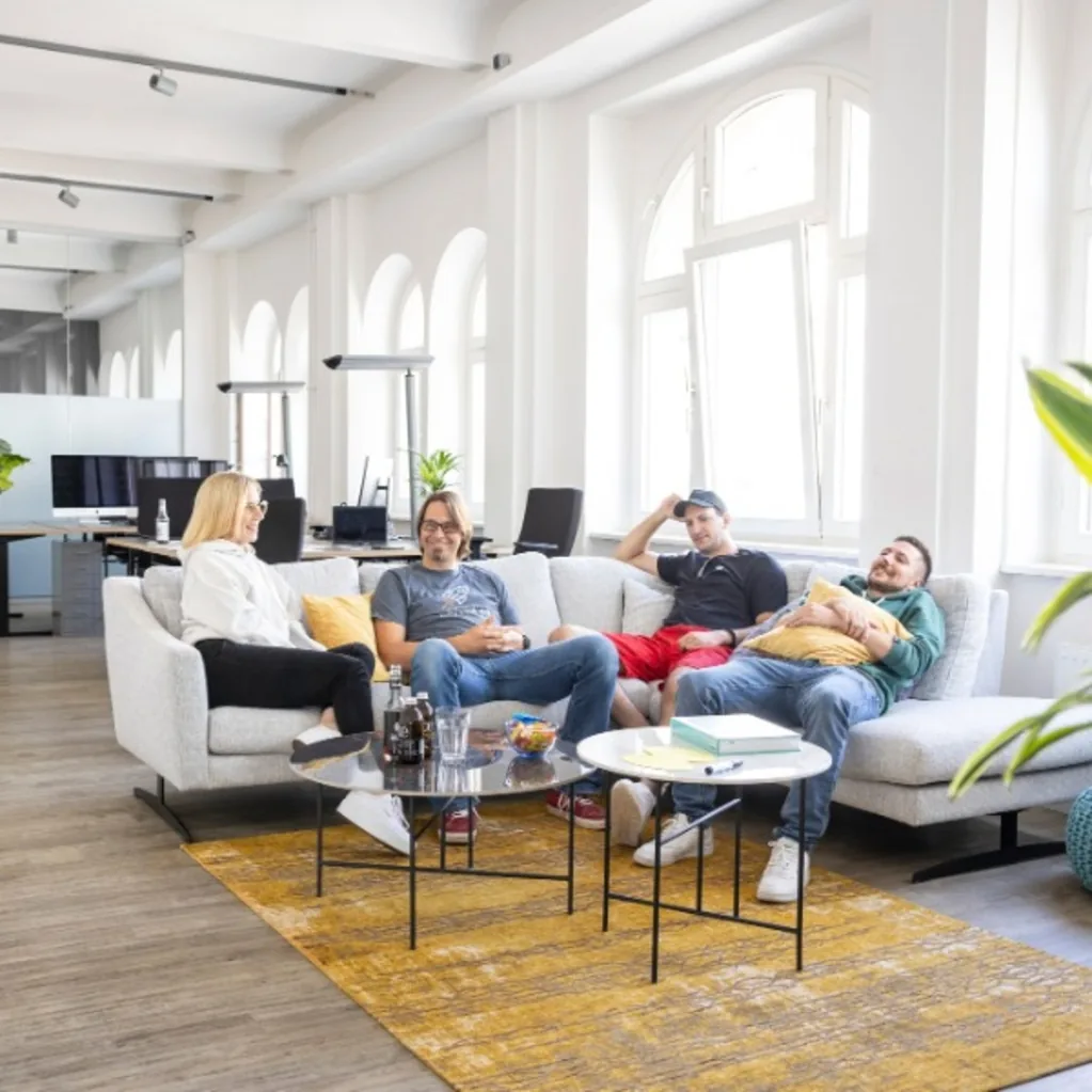 Four colleagues on the sofa in the bright period office
